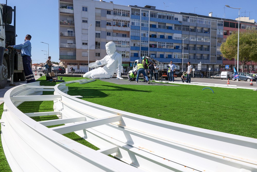 A escultura de um menino a brincar com um comboio numa linha infinita, de Ricardo Romero, começou a ser instalada na Rotunda da Praça do Brasil