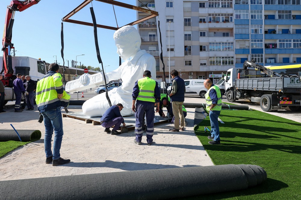 A escultura de um menino a brincar com um comboio numa linha infinita, de Ricardo Romero, começou a ser instalada na Rotunda da Praça do Brasil