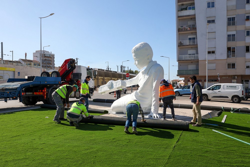 A escultura de um menino a brincar com um comboio numa linha infinita, de Ricardo Romero, começou a ser instalada na Rotunda da Praça do Brasil