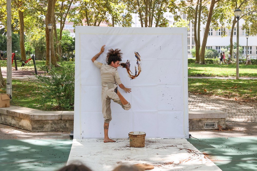 Uma tela pintada em movimento com acrobacias dançadas e equilibradas nas mãos